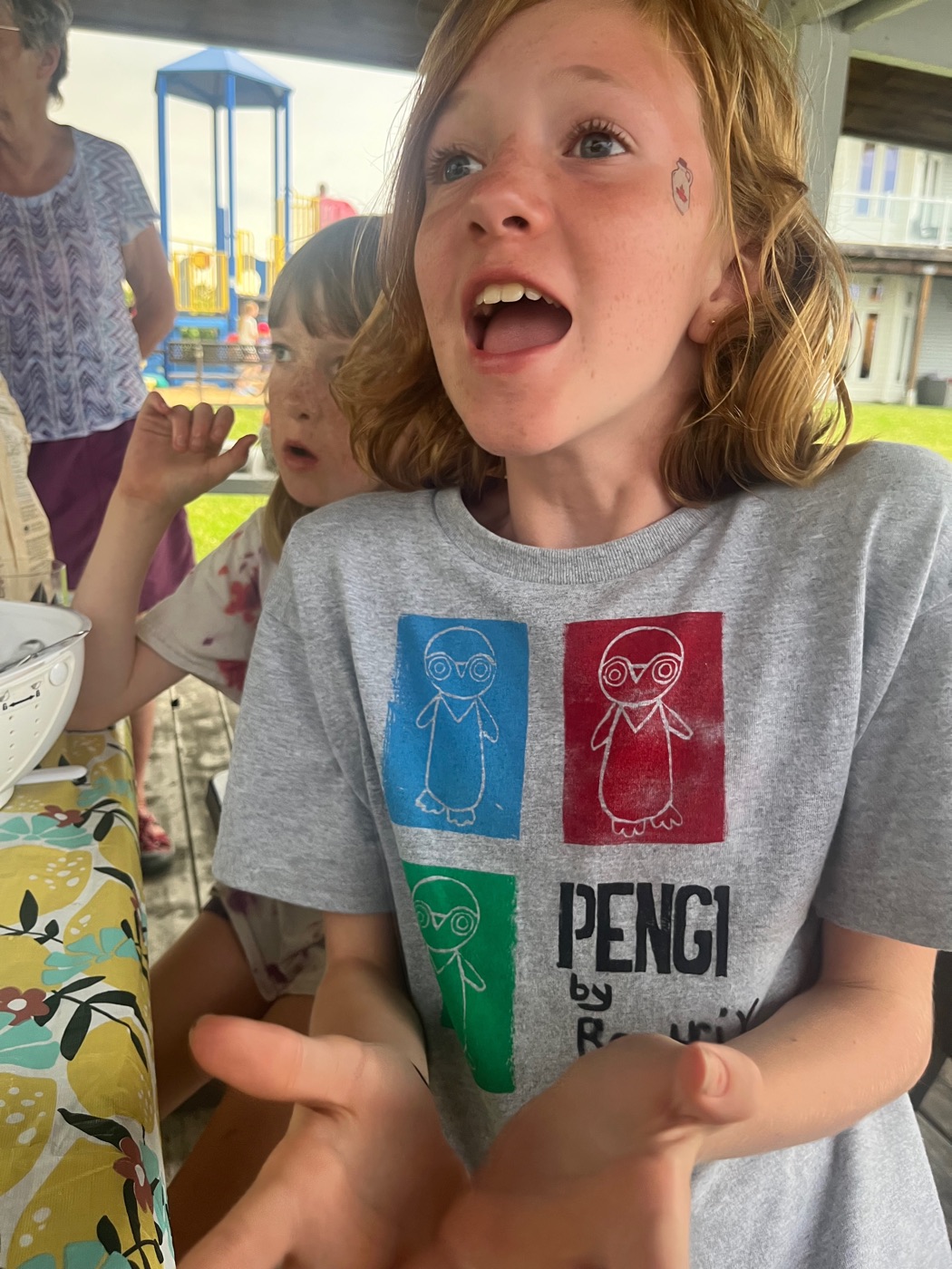 Kid at outdoor event wearing grey Pengi shirt