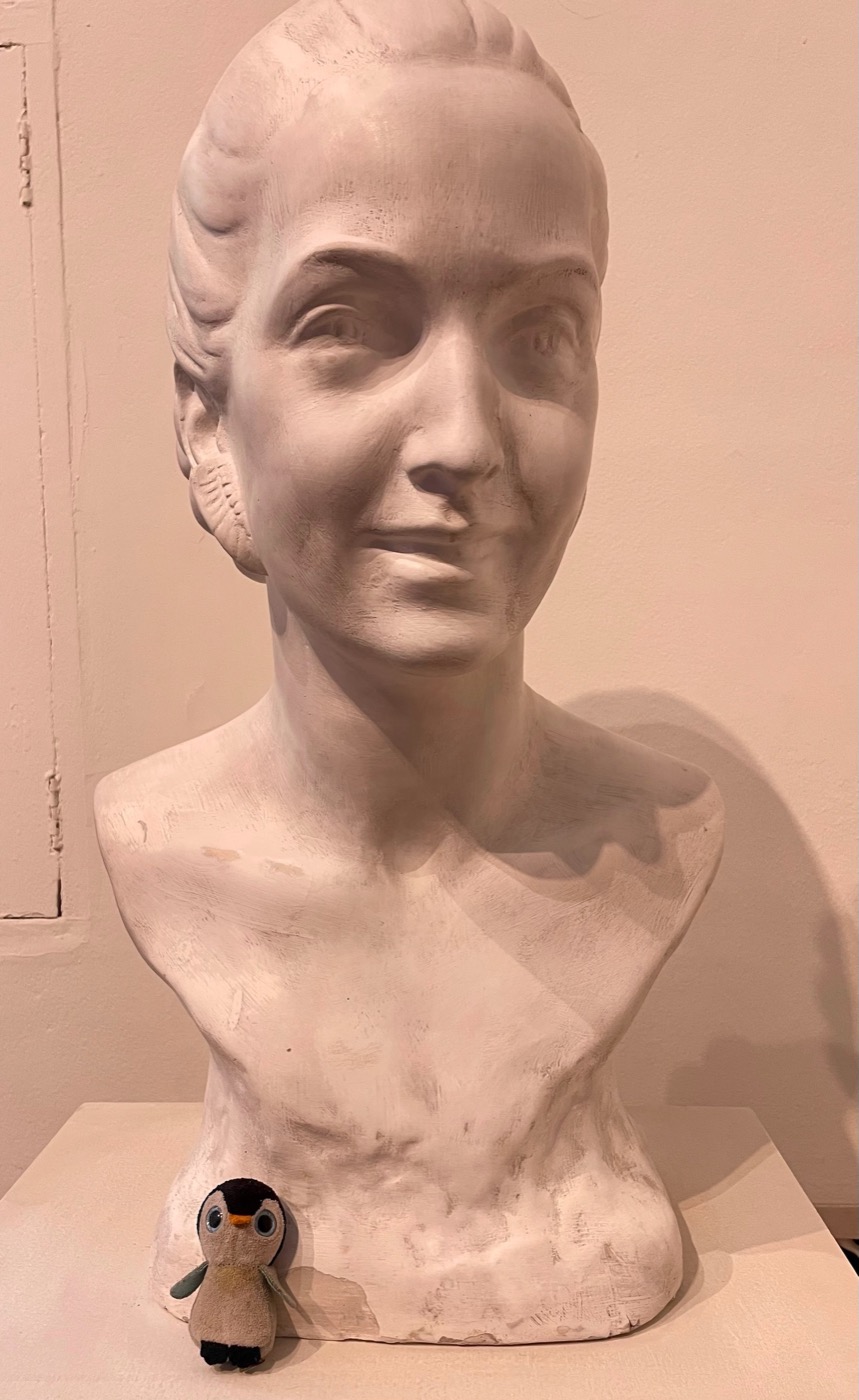 Pengi at the art gallery beside a white sculpted bust